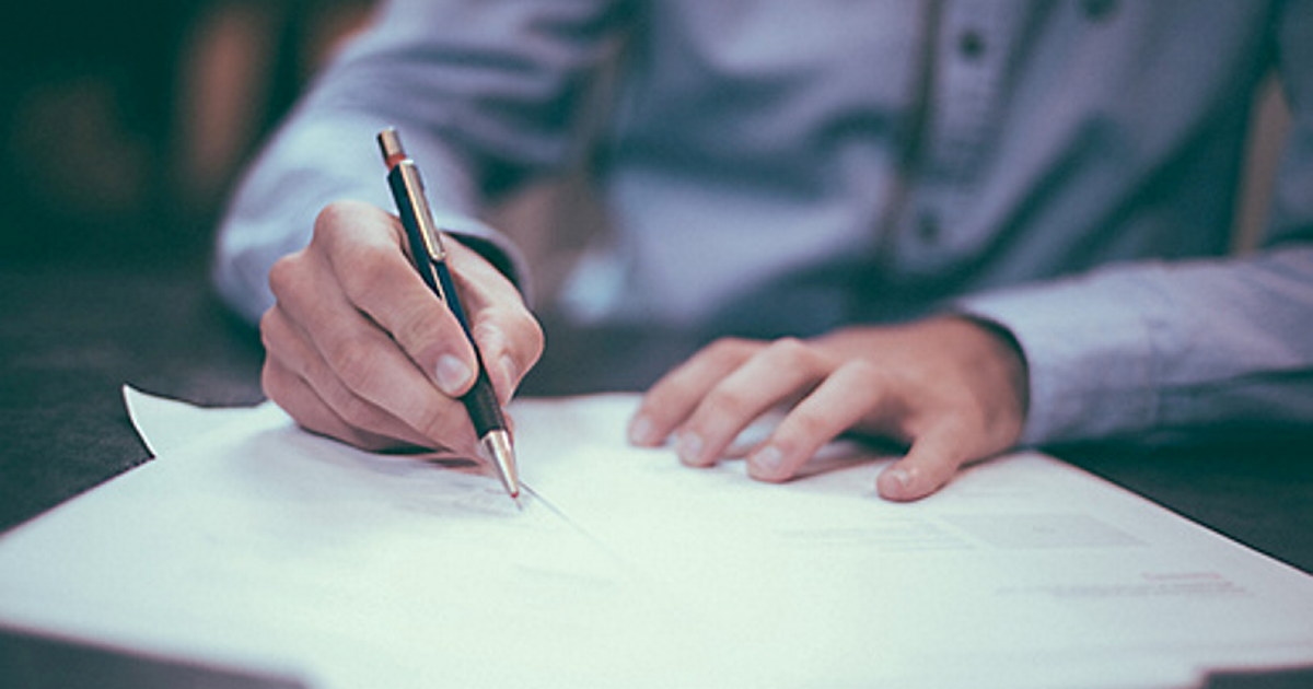 mann signerer papirer