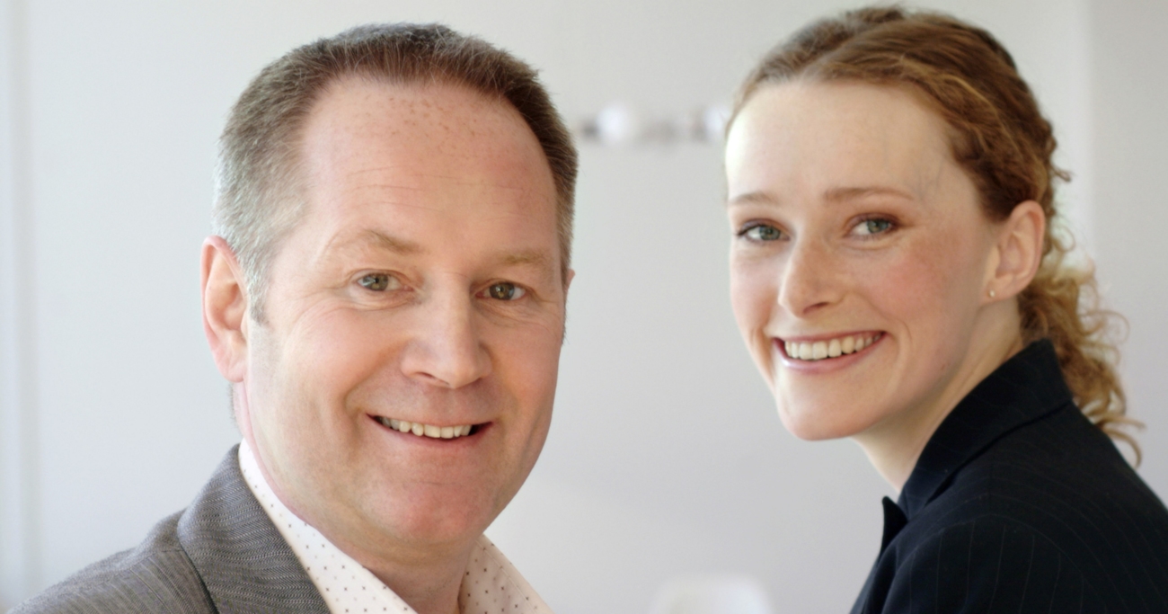 mann og kvinne på arbeidsplass smiler