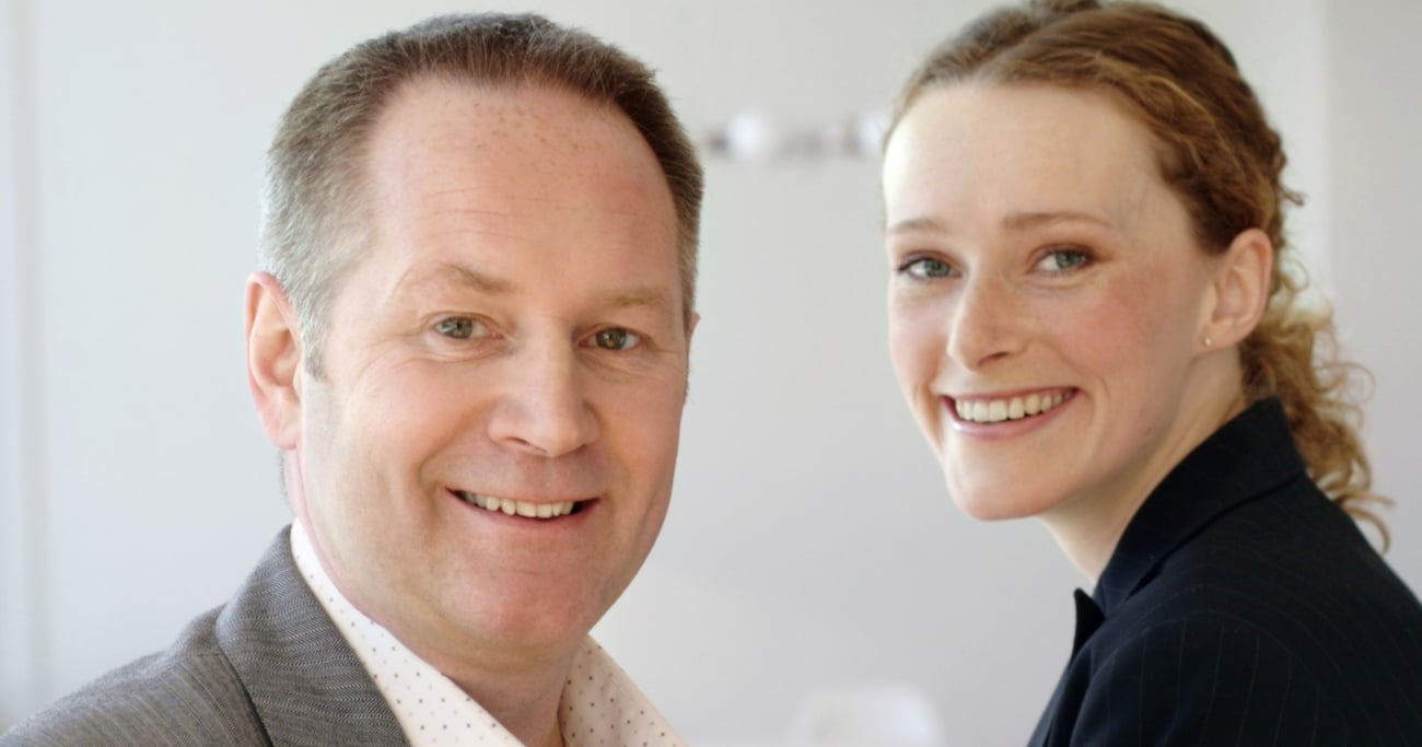 mann og kvinne på arbeidsplass smiler