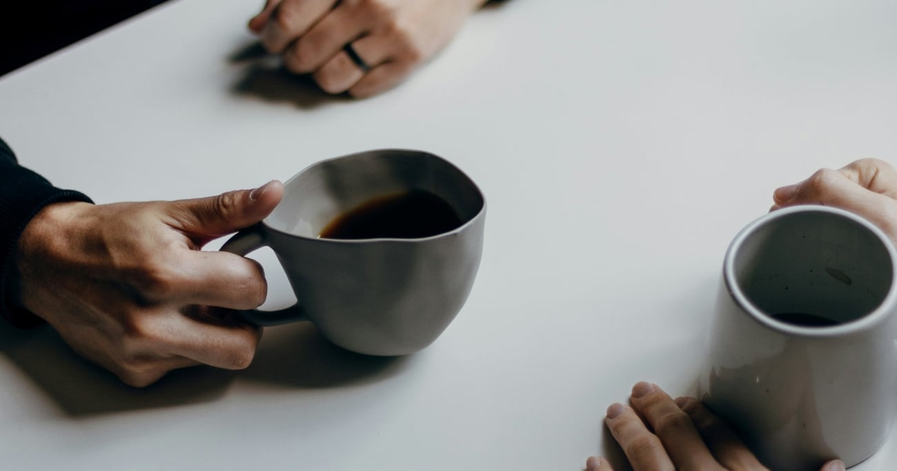 to personer drikker kaffe. bilde av kopper og hender