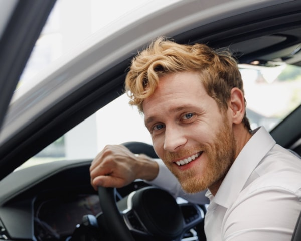 blid ung mann setter jeg inn i en bil hos en forhandler