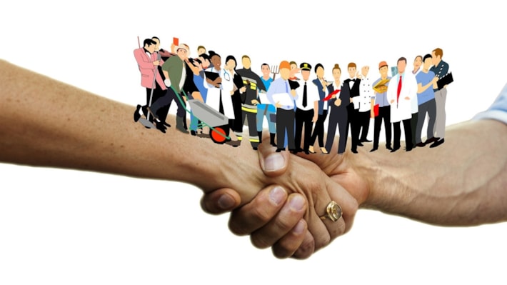 Handshake. Figurer av flere forskjellige yrker står på hver underarm.