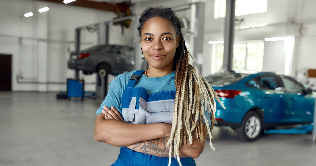 Mørkhudet kvinnelig mekaniker i bilverksted